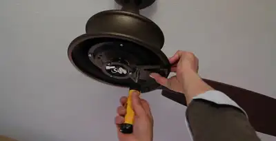 Electrician installing ceiling fan mounting bracket and fixture in Charlotte, NC