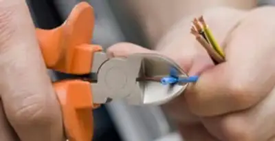 licensed electrician performing precise wire cutting and preparation during electrical service in Charlotte, NC