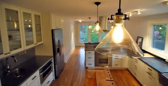 Residential electrician installing modern indoor light fixture in a home in Charlotte, NC