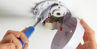 Certified technician wiring smoke detector during installation in Charlotte, NC